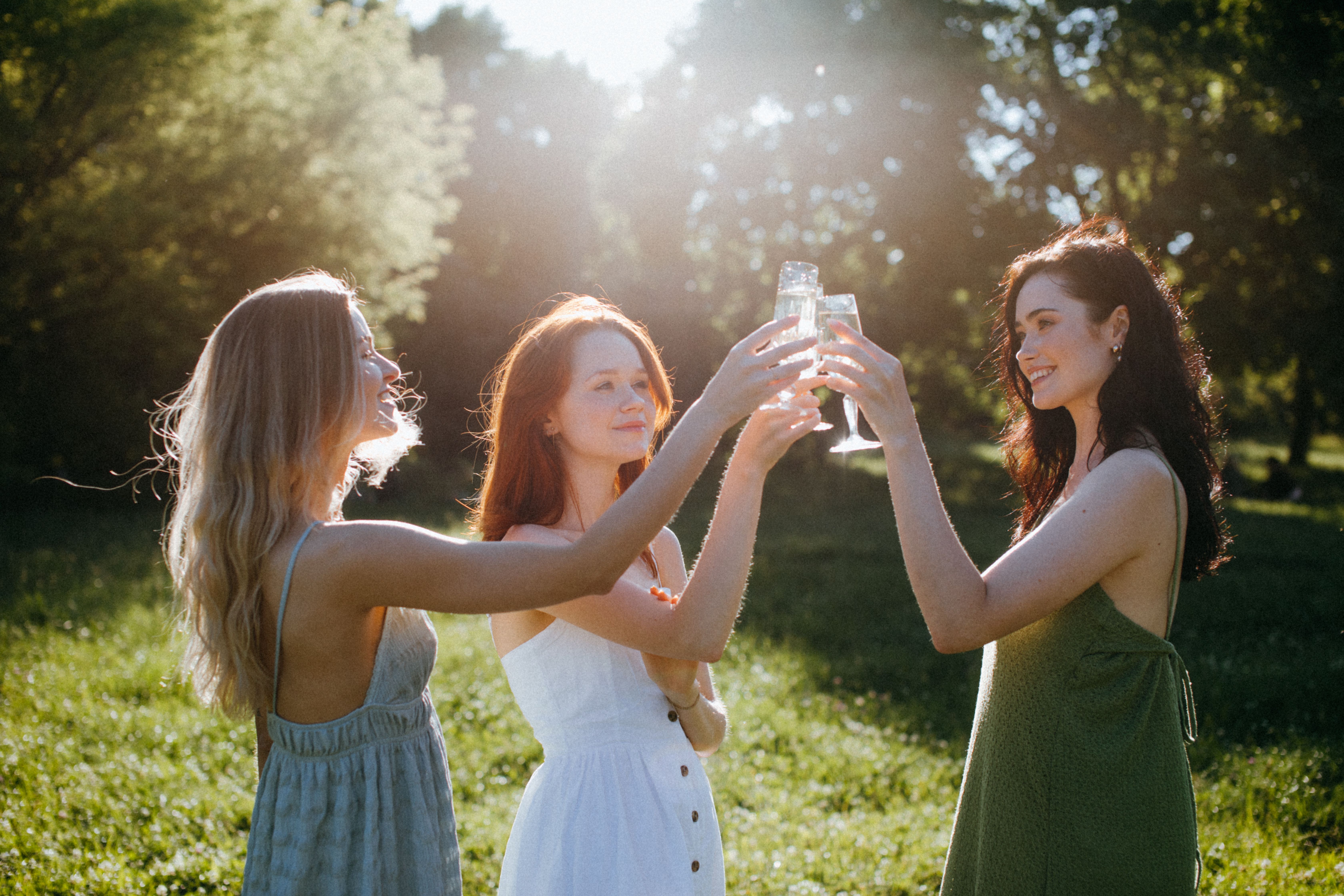 Three friends sharing a sunlit moment outdoors